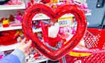 hand holding a red heart shaped wreath in front of a 90% off clearance signage at Target