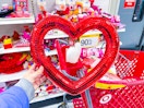 hand holding a red heart shaped wreath in front of a 90% off clearance signage at Target