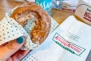 someone holding a pumpkin spice cake donut from krispy kreme