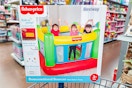 Fisher-price indooor bouncer on edge of Walmart shopping cart