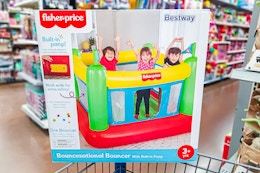 Fisher-price indooor bouncer on edge of Walmart shopping cart