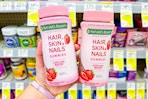 person holding 2 bottles of hair skin nails gummies