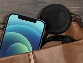 black wireless charging pad with phone in a bag