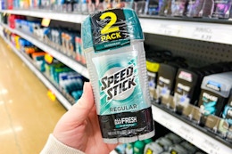 person holding speed stick deodorant in front of other deodorant