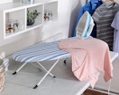 a ironing board, shirt, and iron on a table in a room