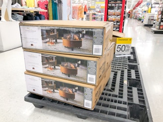 three boxes of fire pits stacked on a pallet inside Target