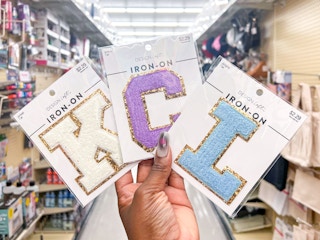 Someone holding iron on letters that spells KCL inside Hobby Lobby