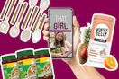 Hand holding phone with 'That Girl Kitchen Upgrades' video, surrounded by Knorr seasoning jars, Wonderbelly antacid, and fresh fruit