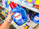 person grabbing persil detergent from a shelf
