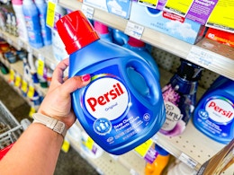 person grabbing persil detergent from a shelf