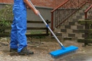 a man using an outdoor broom