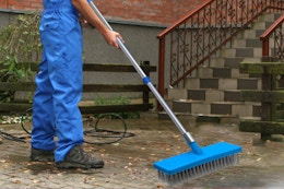 a man using an outdoor broom