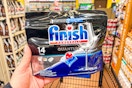 hand holding a pack of finish dishwasher tablets