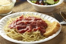 spaghetti on a foam plate on a table 