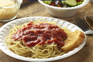 spaghetti on a foam plate on a table 