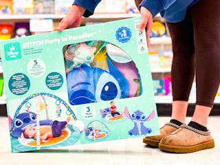hand holding a disney baby stitch activity gym in front of target toys
