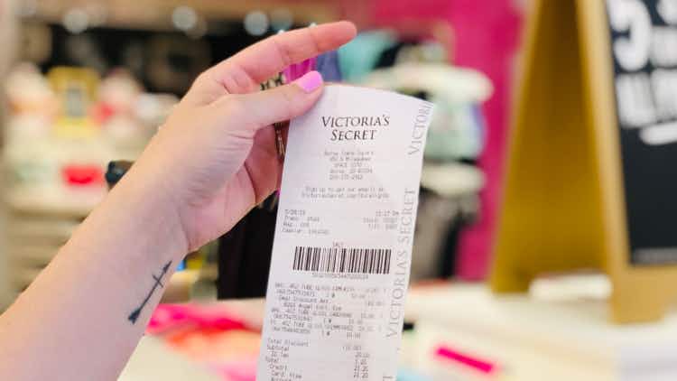 Hand holding Victoria's Secret receipt 