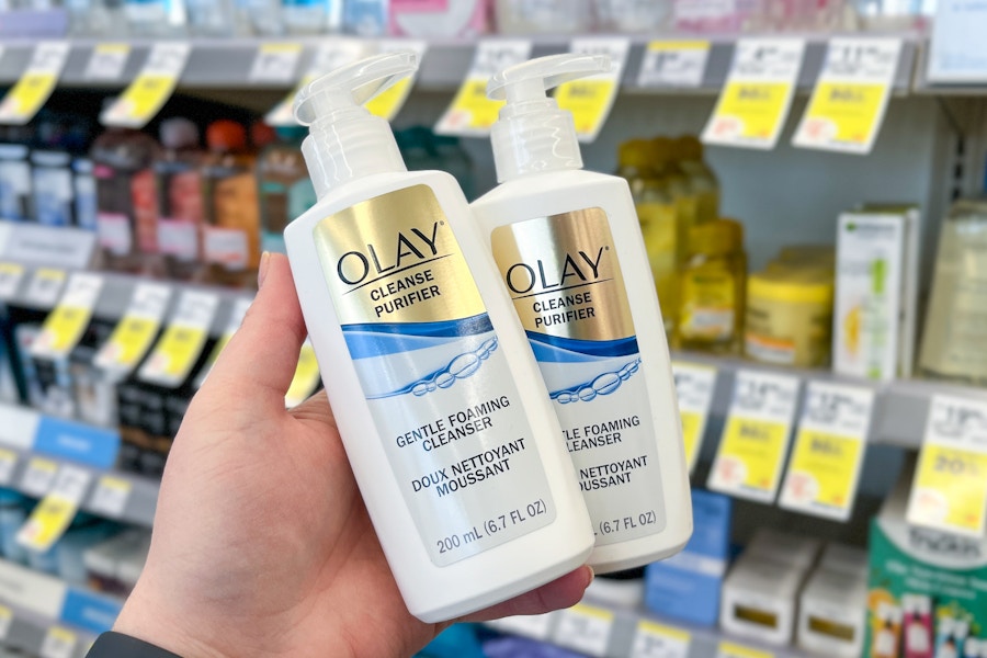 person holding 2 olay cleansers