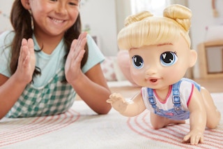 a girl playing with a baby alive doll