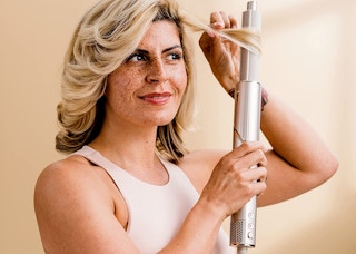 woman styling her hair with the shark flexstyle hair styling system