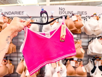 hand holding a hanger with a no boundaries bralette in the walmart bra aisle