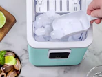 a hand scooping ice out of an ice maker