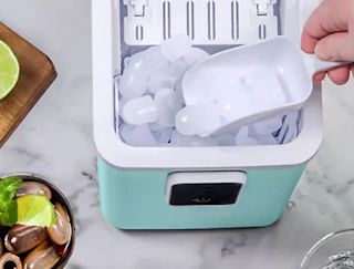 a hand scooping ice out of an ice maker