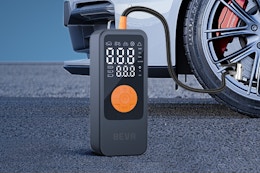 BEVA Tire Inflator Portable Air Compressor on the ground by a car tire.