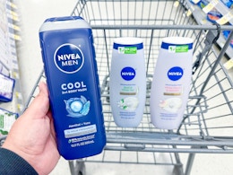 person holding mens nivea body wash over a cart with more nivea body wash in it