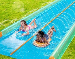 two kids sliding on a water slide 