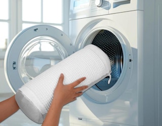 a person putting a shoe laundry bag in the washer