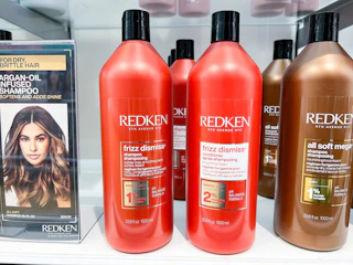 Redken Frizz Dismiss Shampoo and Conditioner on shelf next to other Redken products