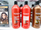 Redken Frizz Dismiss Shampoo and Conditioner on shelf next to other Redken products