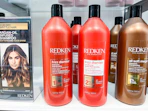 Redken Frizz Dismiss Shampoo and Conditioner on shelf next to other Redken products