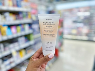 hand holding bottle of Covergirl cream cleanser in aisle