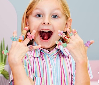 a little girl with toy rings on her fingers