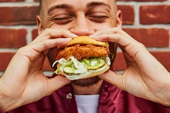a person eating a shake shack chicken sandwich