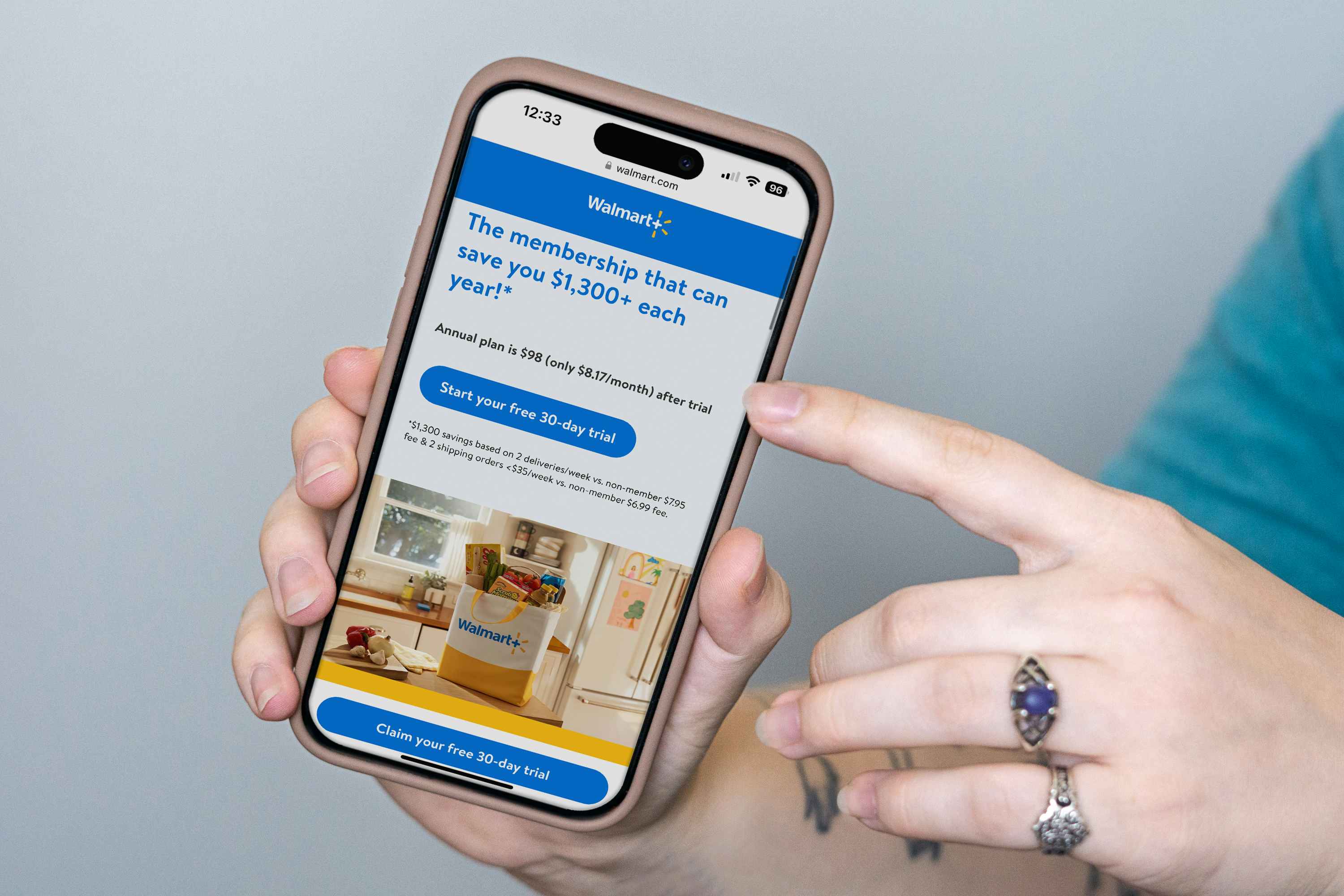 someone holding a phone displaying the webpage for Walmart Plus free trial