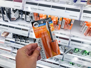 hand holding Covergirl Lashblast mascara in front of shelf