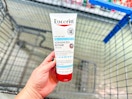 hand holding a bottle of Eucerin body cream