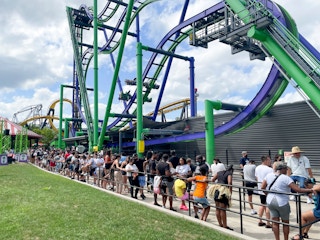 A line of people waiting to ride a roller coaster
