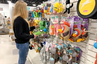 A woman shopping for dog toys in the pet supply section.