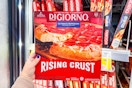 person holding a digiorno frozen pizza