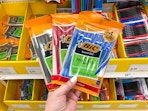 hand holding 3 packs of bic pens in front of a target shelf