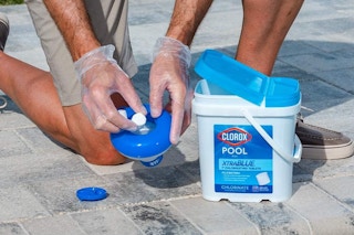 Person inserting chlorine tablet into compartment