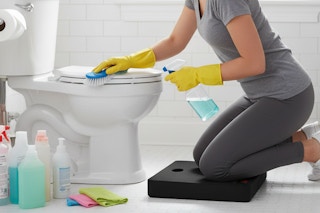 a woman kneeling while cleaning