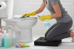 a woman kneeling while cleaning