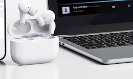 a pair of earbuds next to a laptop