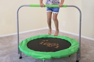 a girl jumping on a mini trampoline