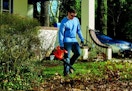 a person using a leaf blower to blow leaves in a yard